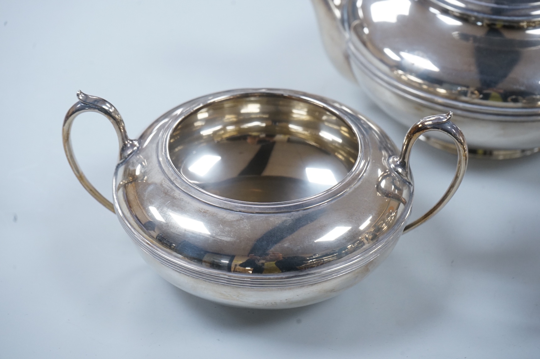 A George V three piece silver tea set, each piece of compressed globular form by James Dixon and Sons, Sheffield 1910, 1025g gross